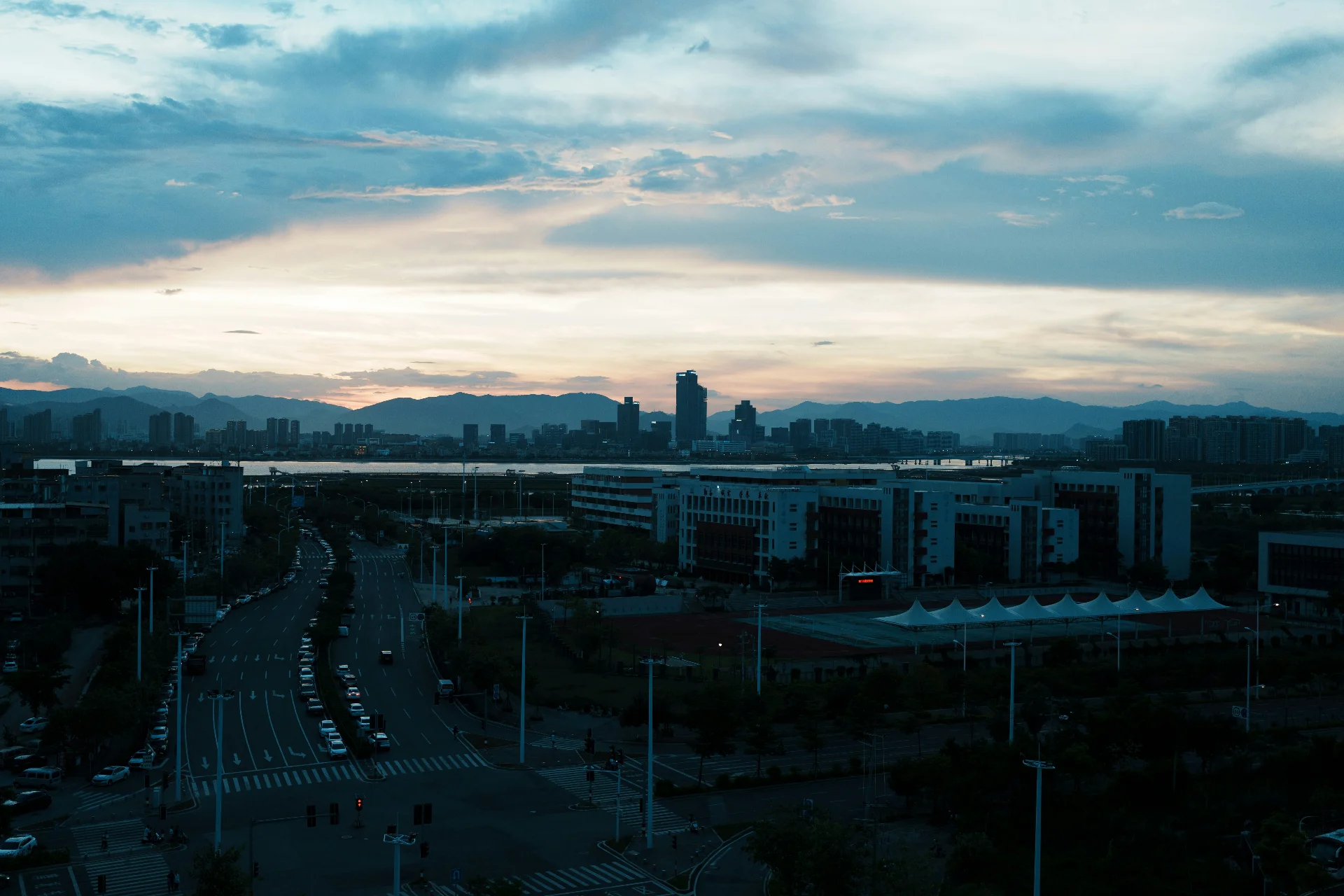 Cityscape at dusk with mountains in the background